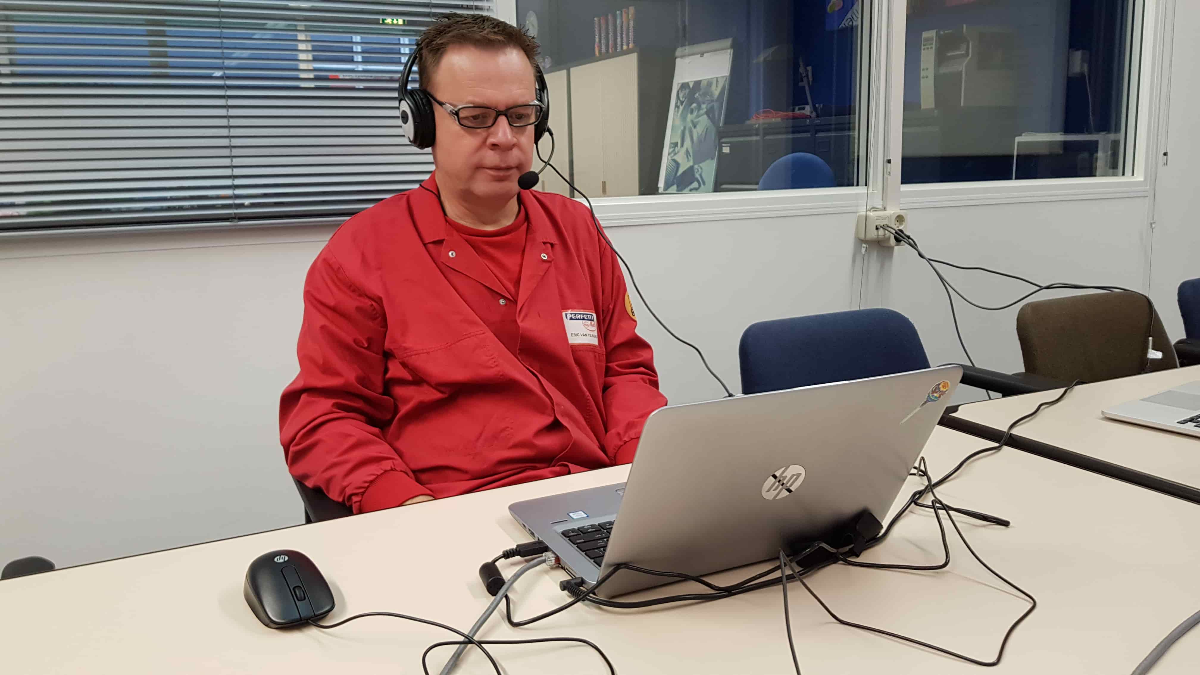 monteur met koptelefoon op achter laptop
